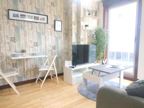 a living room with a television and a table at Loft abuela Flora centro de Vigo in Vigo
