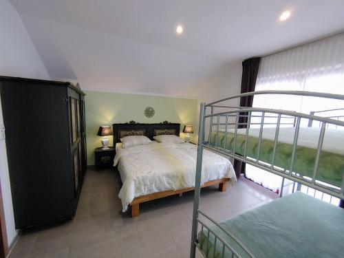 a bedroom with a large bed and a balcony at Landhaus Karawankenblick in Himmelberg