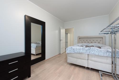 a bedroom with a bed and a dresser and a mirror at Padriku Apartment with a balcony,near to central,Self Check In 24 7,FREE Parking in Tallinn