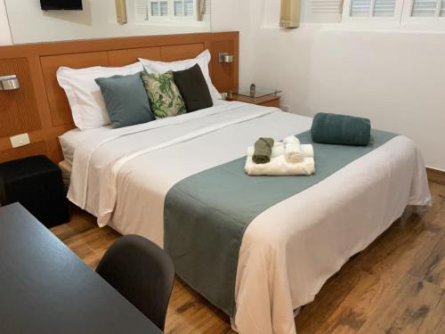 a bedroom with a large bed with two towels on it at Casa da Marquês in Petrópolis