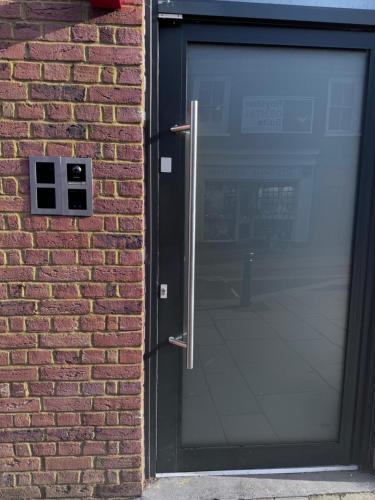 a door in a brick wall with a window at New 2 Bed Apartment in Royston High St in Royston