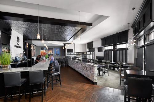 a restaurant with a bar with chairs and tables at Crowne Plaza Providence-Warwick (Airport) by IHG in Warwick