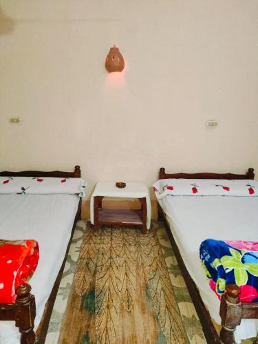 a room with two beds and a table in it at Sunset Mirage in Luxor