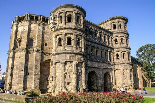 a large stone building with people walking around it at Holiday Inn Express - Trier by IHG in Trier