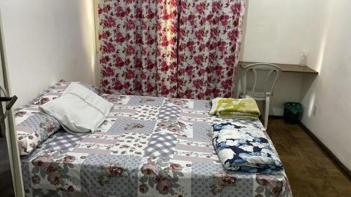 a bed with a quilt on it in a bedroom at Mariazi Hostel in Rio de Janeiro