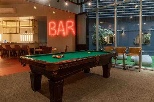 a pool table in a room with a bar sign at Opta Coliving Punta Carretas in Montevideo