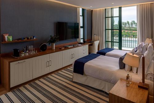 a hotel room with a bed and a television at Boa Vista Surf Lodge in Pôrto Feliz