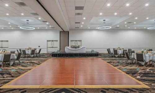 a banquet hall with tables and chairs and a wooden floor at Staybridge Suites Oxnard - River Ridge by IHG in Oxnard