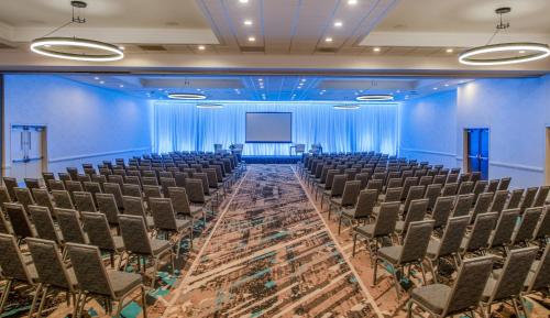 an empty room with chairs and a projection screen at Staybridge Suites Oxnard - River Ridge by IHG in Oxnard