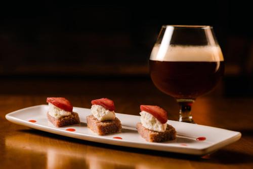 a plate with four desserts and a glass of beer at Fiesta Americana Acapulco Villas in Acapulco