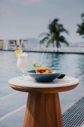 a bowl of food and a drink on a table next to a pool at Fiesta Americana Acapulco Villas in Acapulco
