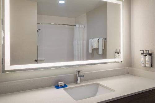 a bathroom with a sink and a large mirror at Holiday Inn Express & Suites Midwest City by IHG in Midwest City