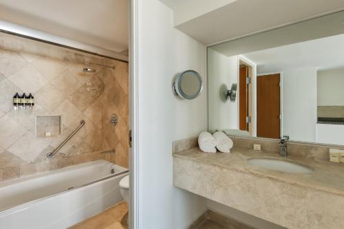 a bathroom with a sink and a tub and a mirror at Fiesta Americana Acapulco Villas in Acapulco