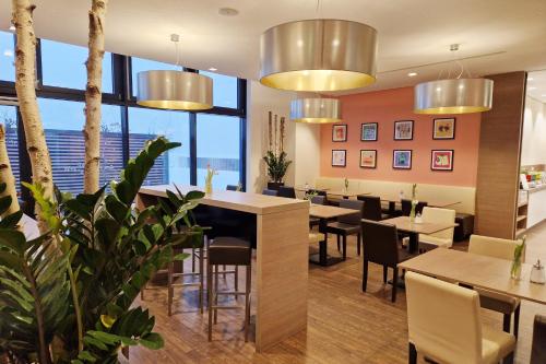 a restaurant with tables and chairs and large windows at Garner Hotel Berlin - Charlottenburg, an IHG Hotel in Berlin