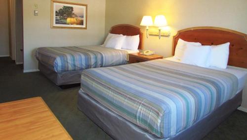 a hotel room with two beds and a telephone at Magnuson Grand Pioneer Inn and Suites in Escanaba