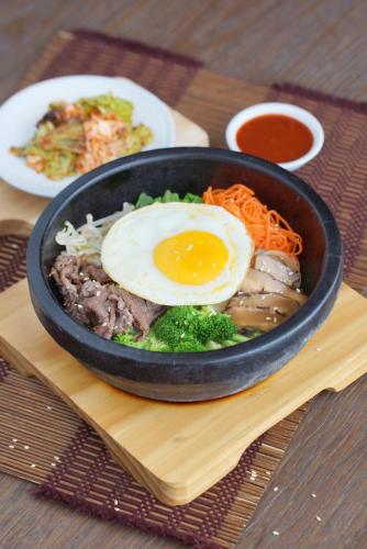 a black bowl of food with an egg on top at Ayaka Suites in Jakarta