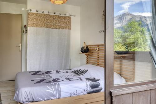 - une chambre avec un lit et une vue sur la montagne dans l'établissement Appartement Cosy - 1 à 2 chambres proche thermes et ski, à Saint-Gervais-les-Bains