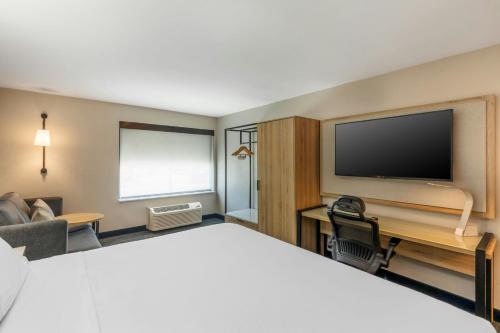 a hotel room with a bed and a flat screen tv at City Express by Marriott Duluth in Duluth