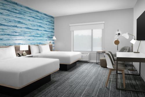 a hotel room with two beds and a desk at TownePlace Suites By Marriott Lake City in Lake City
