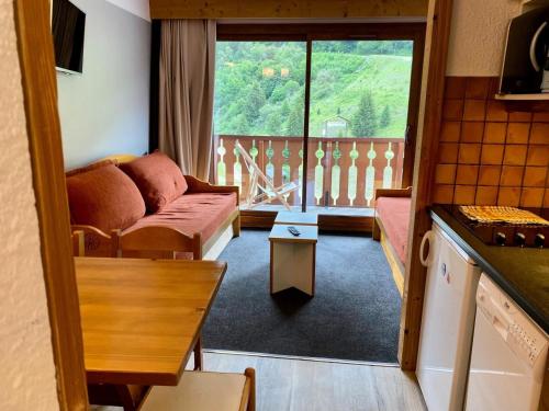 d'un salon avec un canapé et un balcon. dans l'établissement Résidence Les Sentiers du Tueda - maeva Home - Studio 4 personnes - Sélection MAE-1151, à Les Allues