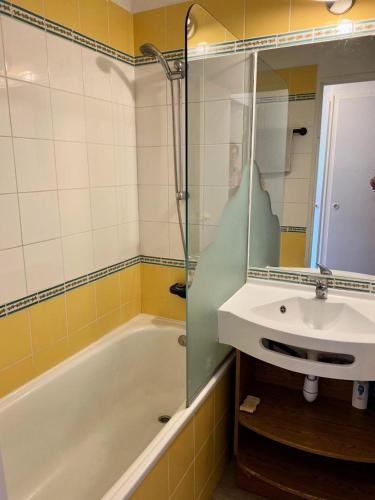 une salle de bain avec un lavabo, une baignoire et un miroir dans l'établissement Résidence Les Sentiers du Tueda - maeva Home - Studio 4 personnes - Sélection MAE-1151, à Les Allues