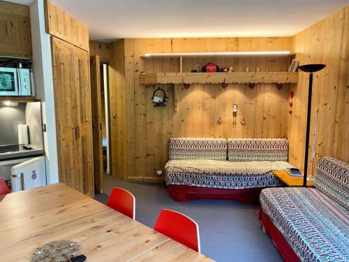 Cette chambre comprend un lit et un mur en bois. dans l'établissement Résidence Les Sentiers du Tueda - maeva Home - Appartement 5 pièces 8 personnes - Sélection MAE-1401, à Les Allues