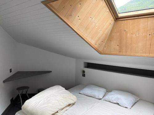 - une chambre avec un lit et un toit en bois dans l'établissement Résidence Les Sentiers du Tueda - maeva Home - Appartement 5 pièces 8 personnes - Sélection MAE-1401, à Les Allues