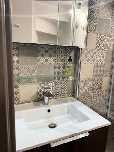 une salle de bain avec un lavabo blanc et un miroir dans l'établissement Résidence Les Sentiers du Tueda - maeva Home - Appartement 5 pièces 8 personnes - Sélection MAE-1401, à Les Allues