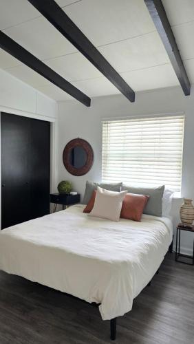 a bedroom with a large white bed with pillows at 904 Nomad's Nest Mid-Century modern entertainment home with cabin vibes, 2 MEGA gamerooms, pingpong, pooltable, gym, patio in Jacksonville