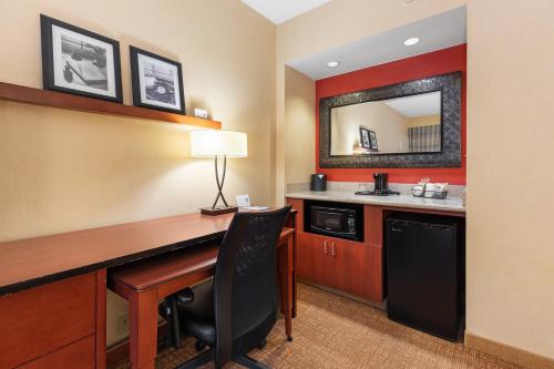 a hotel room with a desk and a mirror at Courtyard Toledo Airport Holland in Holland