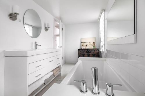 a white bathroom with a sink and a mirror at Hygge House in Harbert