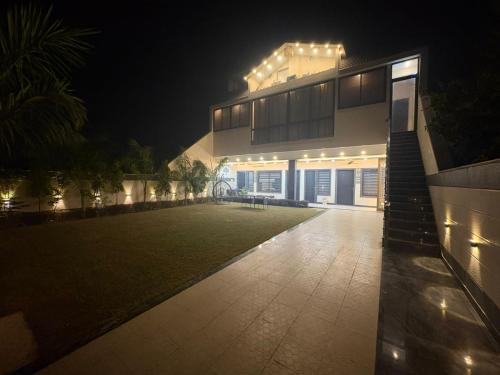 a house with lights on the side of it at night at Mathura Bliss Resort Villa in Mathura