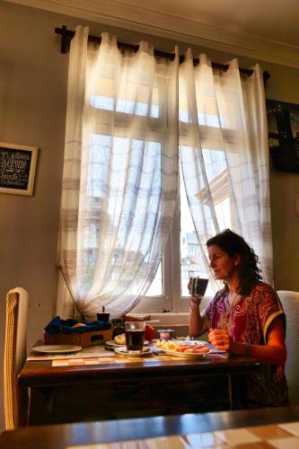 a woman sitting at a table in front of a window at Hostal Boonen in Santiago