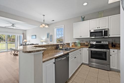 eine Küche mit weißen Schränken und Geräten aus Edelstahl in der Unterkunft World Tour Golf Resort 206 in Myrtle Beach