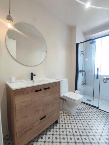 a bathroom with a sink and a toilet and a mirror at Canido con vistas in Ferrol