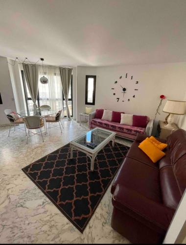 un salon avec un canapé et une horloge au mur dans l'établissement 99 Rue D'Antibes - Spacious & Chic Appartement, à Cannes