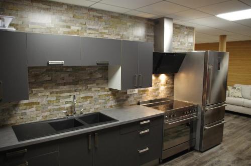 Una cocina con fregadero y frigorífico de acero inoxidable. en Loc-Appart SPM Chambre d'hôtes 3, en Saint-Pierre