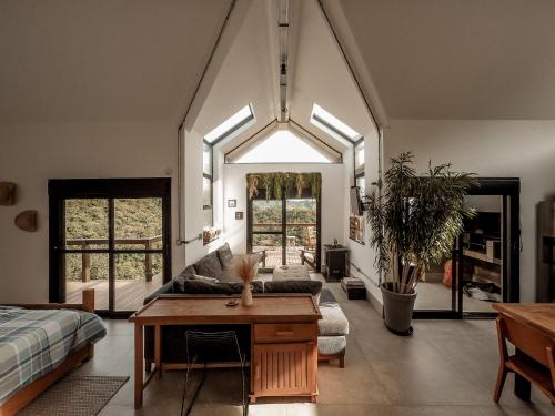 salon z kanapą i stołem w obiekcie Cabana com vista para as montanhas, ofurô e Starlink w mieście Cambuí