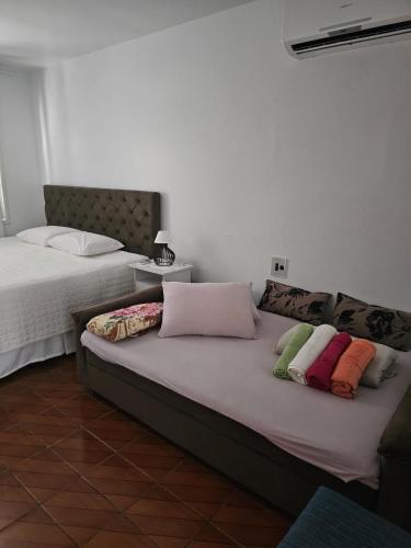 a bed with pillows on it in a room at Descanso para viajantes in São Gabriel