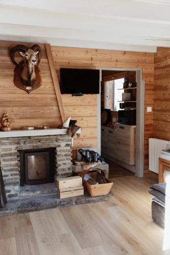 d'un salon avec une cheminée et une tête de bélier sur le mur. dans l'établissement Chalet de l'Ours, 4 étoiles, avec spa et proche des pistes, à La Clusaz