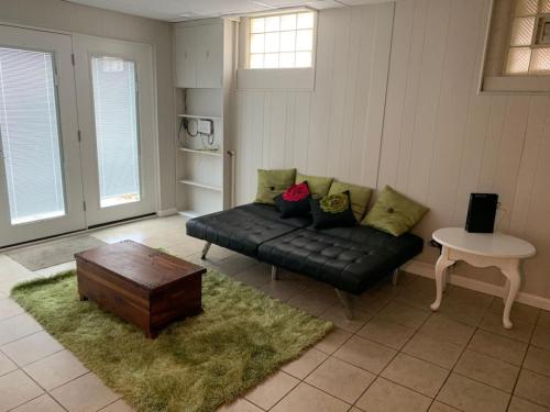 a living room with a black couch and a table at Lovely Retreat Backyard With Deck and entertain room in Mason
