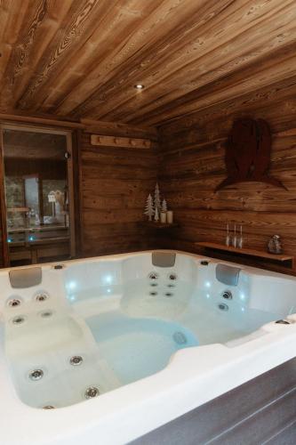 Cette chambre dispose de murs en bois et d'une grande baignoire. dans l'établissement Chalet de l'Ours, 4 étoiles, avec spa et proche des pistes, à La Clusaz