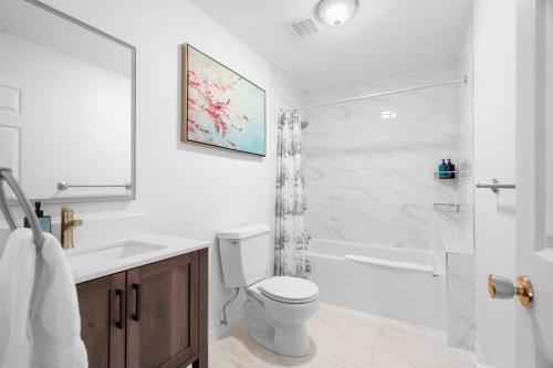 a white bathroom with a toilet and a shower at Chez Dodo Chalet Tremblant 3bdrs condo with fireplace in Mont-Tremblant