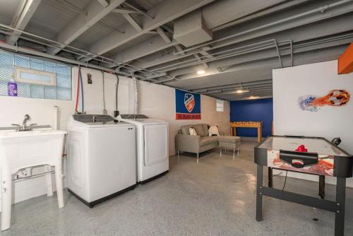 eine Waschküche mit zwei Waschmaschinen und einem Waschbecken in der Unterkunft Dayton Street Sports Haven - 3 Bed 2 Bath Sleeps 8 in Hamilton