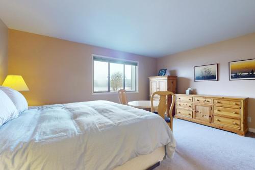 a bedroom with a bed and a dresser and a table at Bayfront Retreat A in Port Ludlow