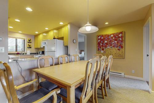 a kitchen and dining room with a wooden table and chairs at Bayfront Retreat A in Port Ludlow