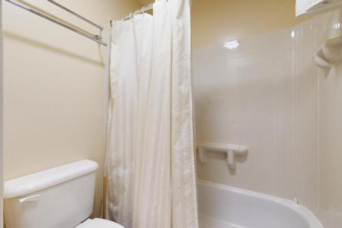 a bathroom with a white shower curtain and a toilet at Bayfront Retreat A in Port Ludlow