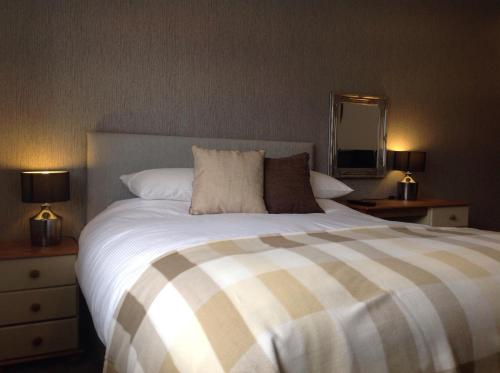 a bedroom with a large bed with a striped comforter at Rooms @ Number Six in Oakham