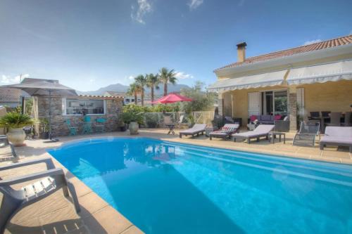 une piscine avec des chaises et une maison dans l'établissement Villa familiale avec piscine à Furiani, 160 m², à Furiani