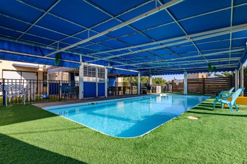 a large swimming pool with a blue roof at עדי הכרמל in Dāliyat el Karmil